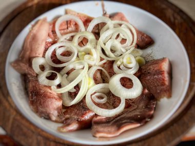 Beyaz tabakta beyaz soğanlı tuzlanmış ringa balığı.