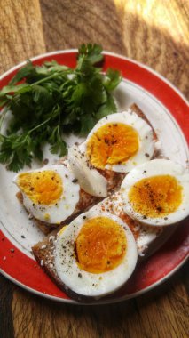 Sağlıklı bir kahvaltıda haşlanmış yumurta, biber ve taze otlarla tatlandırılmış.