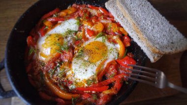 Yumurtalı, biberli, domatesli, şifalı otlu ve ekmekli gönülsüz shakshuka.