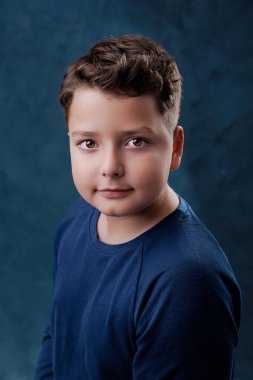 10 year old boy smiling, studio portrait on blue background. clipart