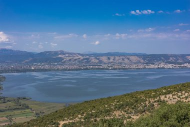Yunanistan 'daki Ioannina Gölü' nün (Pamvotida) muhteşem hava manzarası, yakındaki dağlardan görüldüğü gibi, kıyı şeridi boyunca yerleşik şehir binaları bulunuyor.. 