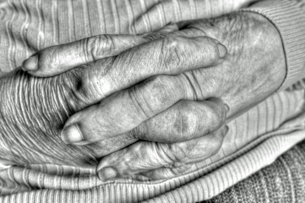 Elderly woman's hands with joined crossed fingers in prayer