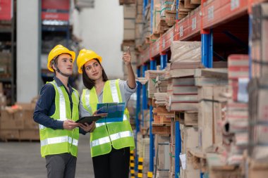 Depo çalışanı büyük bir mağazadaki paketlere bakıyor.