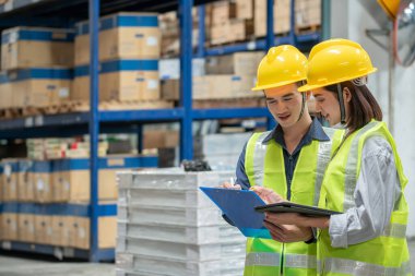 Depo çalışanı büyük bir mağazadaki paketlere bakıyor.