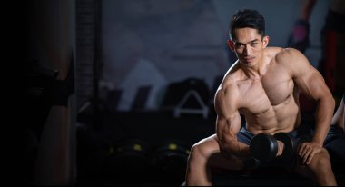 Asyalı adam dambıl çalışıyor. fitness kişisel çalıştırıcı 