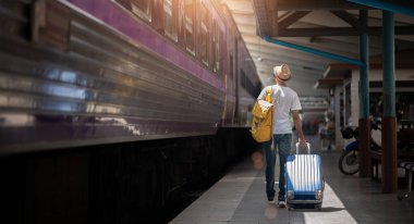 Gezgin yazın yolculuk için tren istasyonunda bekler. Seyahat kavramı.