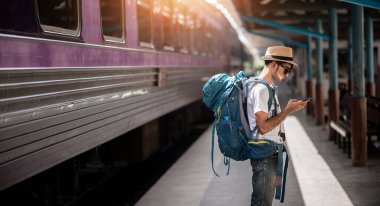 Gezgin yazın yolculuk için tren istasyonunda bekler. Seyahat kavramı.
