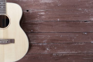Musical instrument - Silhouette of a solid spruce top left handed acoustic guitar on wooden background.