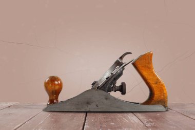 Tools Building and repair - Old rusty metal hand plane closeup a brown wall background.
