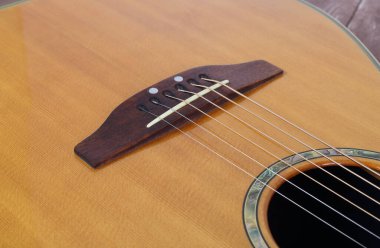 Müzik enstrümanı - Ahşap zemin üzerinde yakın plan köprü elektrikli akustik gitar.