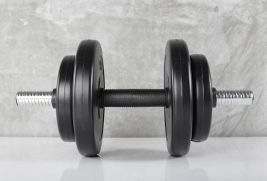 Spor ve zindelik - Ön manzara 4 ağırlığı beton arka plan olan siyah halter