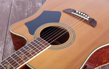 Müzikal enstrüman - Ahşap arka planda yakın plan elektrikli akustik gitar.
