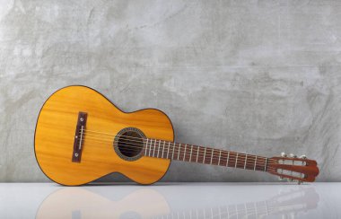 Müzikal enstrüman - Salon akustik gitar arka planında beton bir duvarın altında yansıması olan