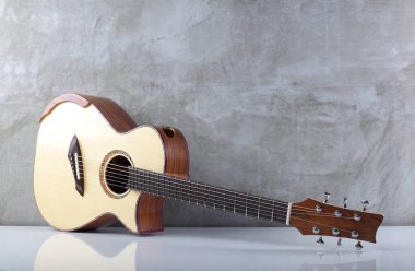 Müzik aleti - Beton duvar arka planında Solid Spruce üst akustik gitar.