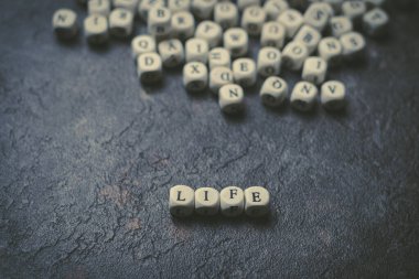 Cubos de madera con letras en fondo negro formando la palabra bondad