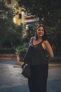 Şehirde uzun kahverengi saçlı, orta yaşlı güzel bir kadının portresi..