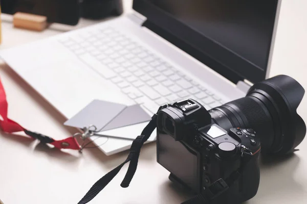 Profesyonel fotoğraf makinesi ve dizüstü bilgisayarı olan fotoğraf masası.