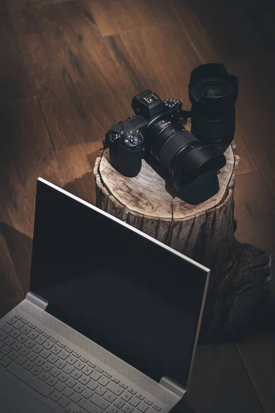 Fotokamera Auf Baumstamm Und Laptop Dunkler Und Rustikaler Umgebung Stockfoto