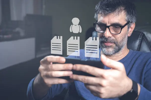 Başarılı, olgun bir iş adamı, işini rahat evinden yönetiyor. İnsan kaynakları, sanal ikonlar ve akıllı telefonları işe almak. İş konsepti.