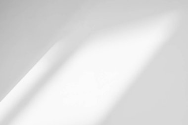 Beyaz duvar arka planındaki pencerenin soyut ışık yansıması ve gri gölgesi, koyu gri gölgeler ve arkaplan ve taklit etme arzusu için güneş ışığı köşegen örtüsü efekti