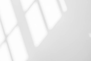 Beyaz duvar arka planındaki pencerenin soyut ışık yansıması ve gri gölgesi, koyu gri gölgeler ve arkaplan ve taklit etme arzusu için güneş ışığı köşegen örtüsü efekti