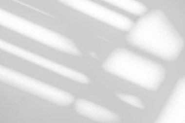 Beyaz duvar arka planındaki pencerenin soyut ışık yansıması ve gri gölgesi, arkaplan ve model için koyu gri gölgeler ve güneş ışığı örtüsü etkisi