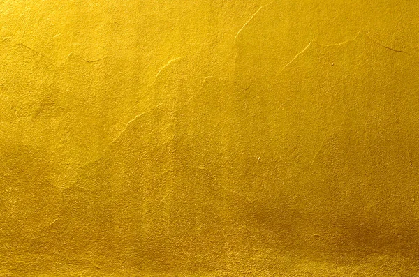 Gold wall texture background. Yellow shiny gold metal sheet surface with light reflection, vibrant golden luxury wallpape