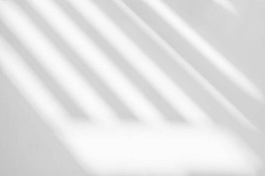 Soyut ışık yansıması ve beyaz duvar arka planındaki pencerenin gri gölgesi. Gri çizgili pencere gölgeleri ve güneş ışığı arkaplan ve model tasarımı için çapraz çizgi efekti