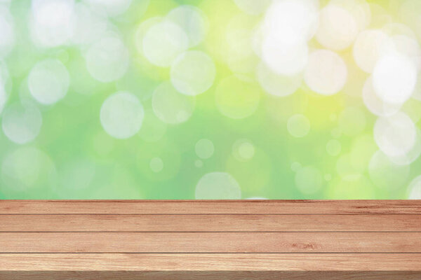 Пустая деревянная столешница или прилавок и солнечный свет размывают боке листьев и деревьев на фоне природы в зеленом весеннем саду для шаблона макет и отображения монтажа продукта. Фон деревянной доски
