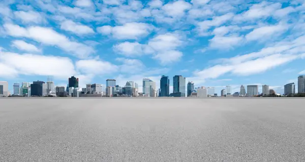 Empty wide asphalt road and city skyline. Side asphalt tarmac floor with buildings and modern cityscape, white clouds and blue sky background, highway for transportation, cloudy sky, high angle vie