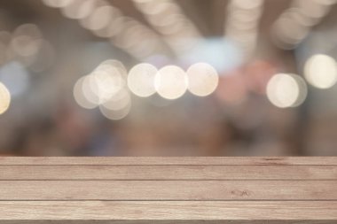 Boş ahşap masa üstü ya da açık bulanık bokeh üzerinde parlayan parlak odaklı ışıklar montaj ürünlerini taklit ediyor. Ürünler için ahşap tahta Noel ışıkları arka gruplandırıcı