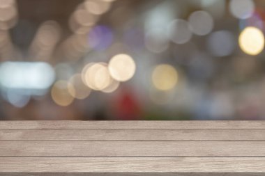 Boş ahşap masa üstü ya da açık bulanık bokeh üzerinde parlayan parlak odaklı ışıklar montaj ürünlerini taklit ediyor. Ürünler için ahşap tahta Noel ışıkları arka gruplandırıcı