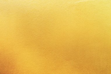 Altın duvar dokusu arka plan. Duvarın yüzeyinde parlak parlak sarı folyo boya, parlak yansımalı, parlak altın renkli duvar kağıdı.