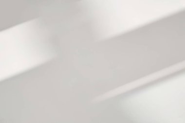 Beyaz duvar arka planındaki pencerenin soyut ışık yansıması ve gri gölgesi, arkaplan ve model için koyu gri gölgeler ve güneş ışığı örtüsü etkisi