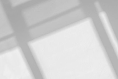 Beyaz duvar arka planındaki pencerenin soyut ışık yansıması ve gri gölgesi, arkaplan ve model için koyu gri gölgeler ve güneş ışığı örtüsü etkisi