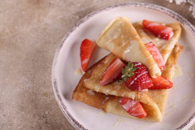 homemade thin pancakes with fresh strawberries
