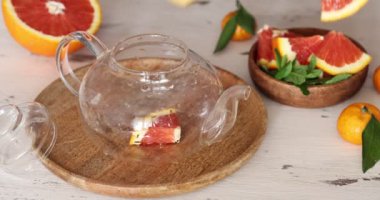 tea with oranges and mint in a glass teapot