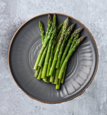 Açık gri arka plan görünümlü taze yeşil kuşkonmaz