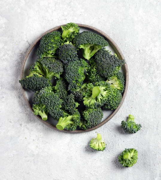 薄緑色の背景に灰色のプレートに新鮮なブロッコリーの野菜トップビュー — ストック写真
