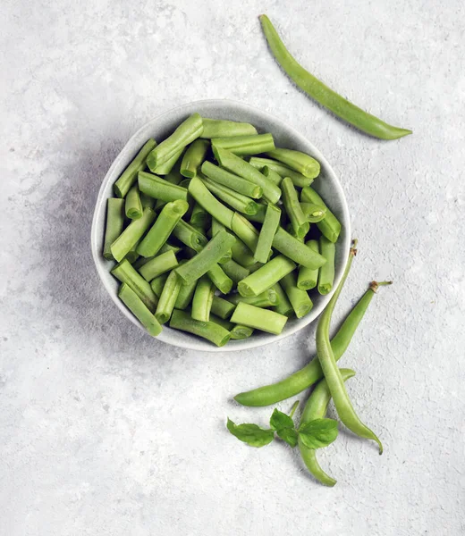 薄緑色の背景の灰色のプレートの新鮮な緑のストリング豆トップビュー — ストック写真