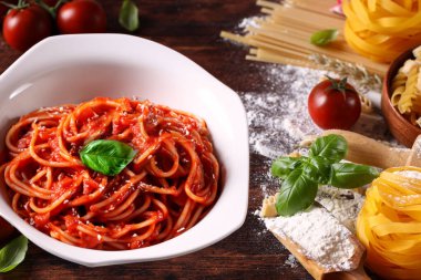 Tahta bir masada ev yapımı makarna ve domates sosu.