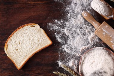 Hamur unu ahşap masada ekmek pişiriyor.