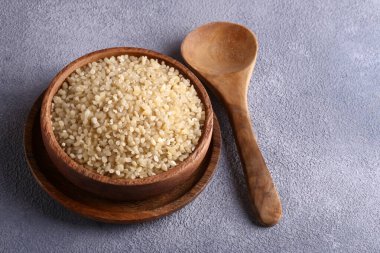 Bulgur ahşap bir kasede masada, sağlıklı yiyecekler.
