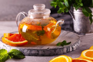 Portakallı detoks çayı ve şeffaf çaydanlıkta nane şekeri.