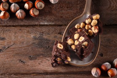 Tahta arka planda fındıklı koyu çikolata