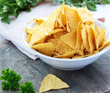 Masadaki beyaz kasede mısır cipsi.