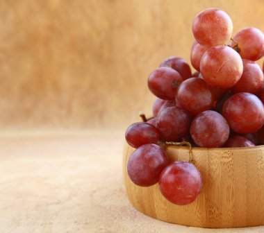 Ahşap masada organik kırmızı üzümler