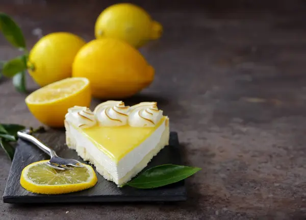 lemon tart with meringue and fresh lemons on the table