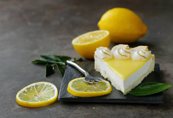 lemon tart with meringue and fresh lemons on the table