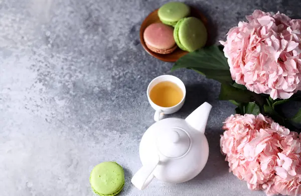 Gri arka planda çaydanlık çayı ve çiçekler